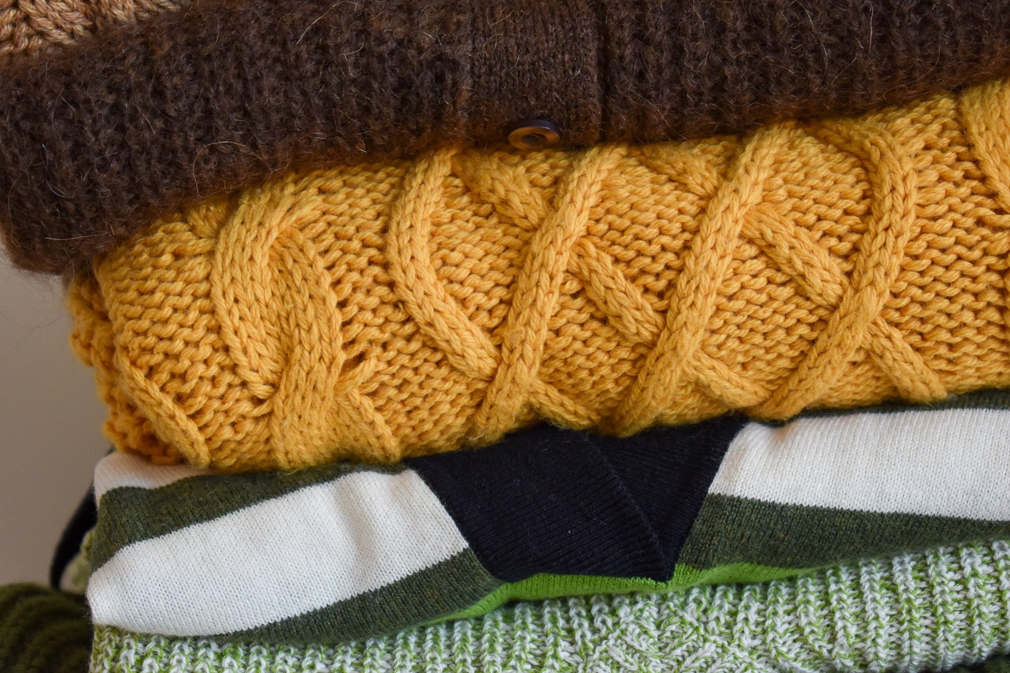 Mustard colour in a stack of knitwear